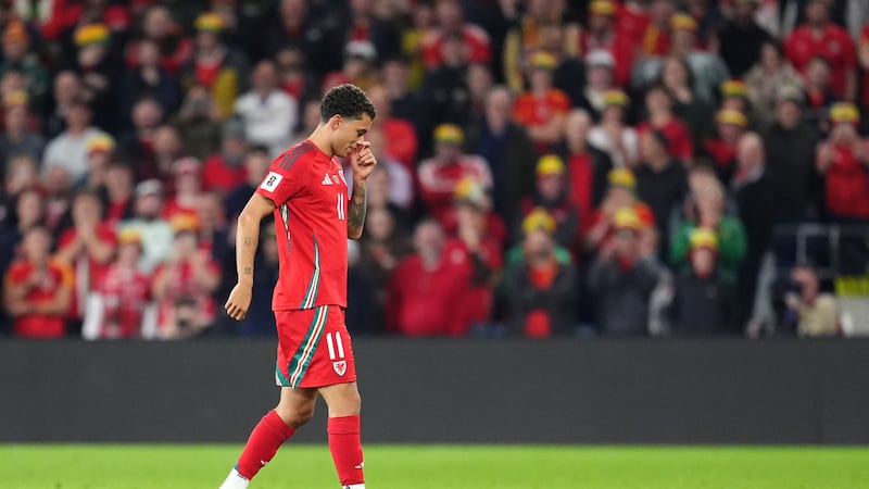 Brennan Johnson, de Gales, persigue a una rata que causó un retraso en el partido de las...