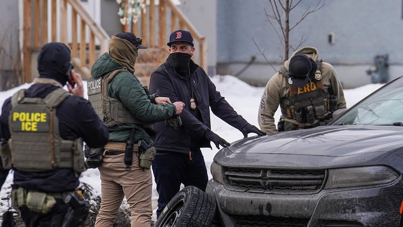 Agentes federales cambian el neumático de un vehículo durante una redada migratoria, el jueves...