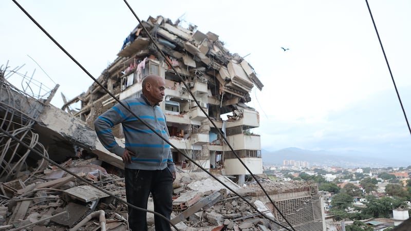 Un hombre permanece de pie entre los escombros de un edificio derrumbado tras un terremoto en...