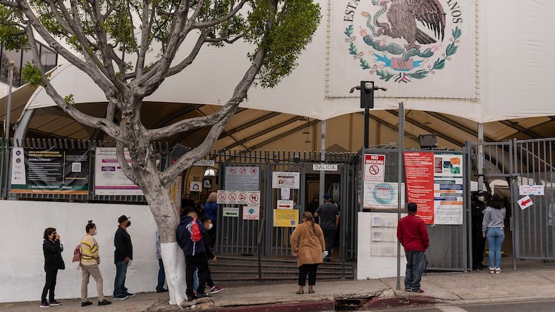 ARCHIVO – Varias personas forman una fila para solicitar servicios en el consulado de México...