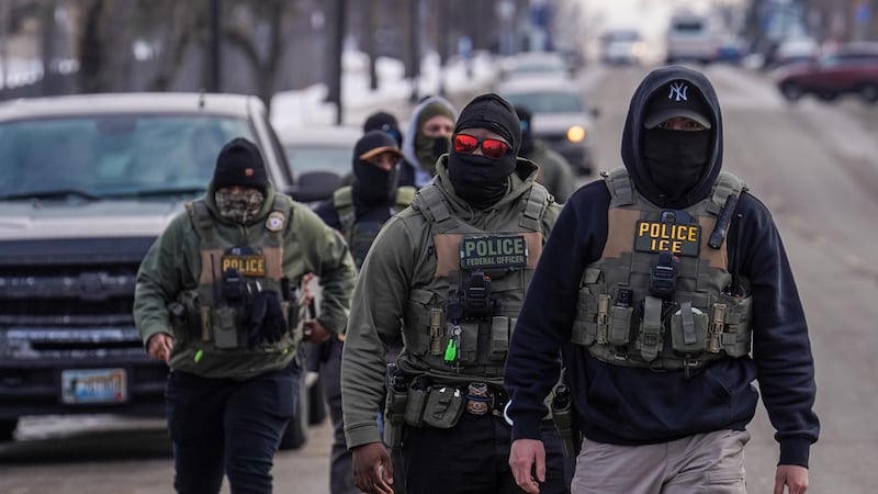 Agentes federales caminan por una calle durante un operativo migratorio, el 5 de febrero de...